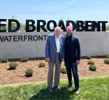 Ed Broadbent standing in front of the park sign